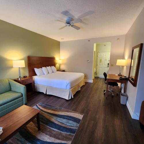 a hotel room with a bed and a couch at Baymont by Wyndham Mackinaw City in Mackinaw City