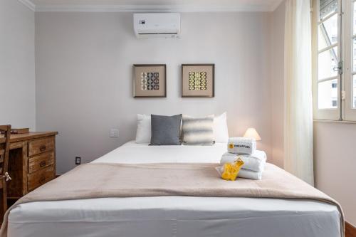 a bedroom with a large white bed with towels on it at Fabuloso em Copacabana - Vista da praia - FMS502 Z4 in Rio de Janeiro