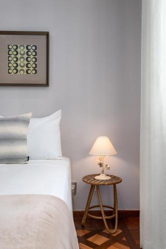 a bedroom with a bed and a table with a lamp at Fabuloso em Copacabana - Vista da praia - FMS502 Z4 in Rio de Janeiro