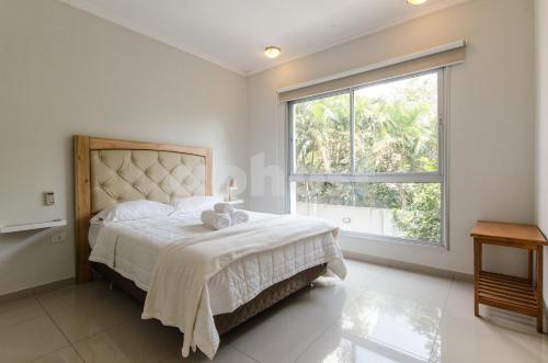 a bedroom with a bed and a large window at Amplio Dpto De 2 Dormitorios Con Parilla in Asuncion