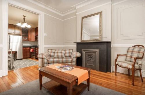 sala de estar con mesa y chimenea en Amazing 3 Bedroom Apartment, en Nueva York