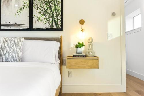a bedroom with a bed and a nightstand with a plant on it at Ellum House in Dallas
