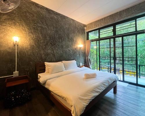 1 dormitorio con cama grande y ventana grande en Morning ธารทอง เชียงใหม่ en Ban Pok Nai