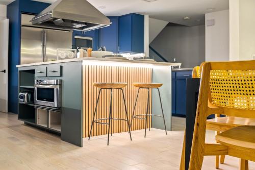 a kitchen with blue cabinets and bar stools at Ellum House in Dallas
