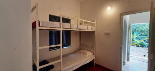Etagenbett in einem Zimmer mit Fenster in der Unterkunft a LoFT in Alappuzha