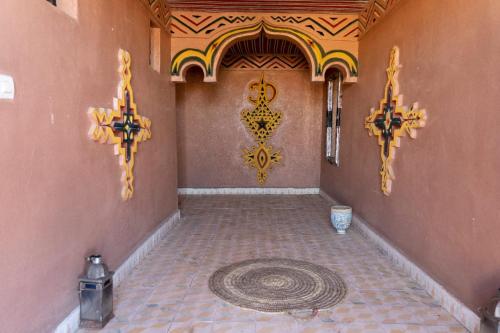 a room with a tile floor and a wall with aocracist at Caravane de Reve in Mhamid