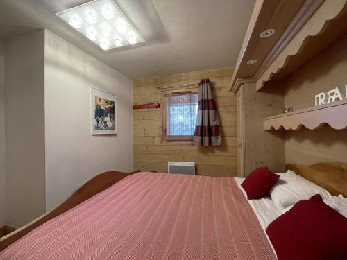 ein Schlafzimmer mit einem großen Bett mit einer rosa Decke in der Unterkunft Appartement Saint-Martin-de-Belleville, 2 pièces, 4 personnes - FR-1-452-193 in Saint-Martin-de-Belleville