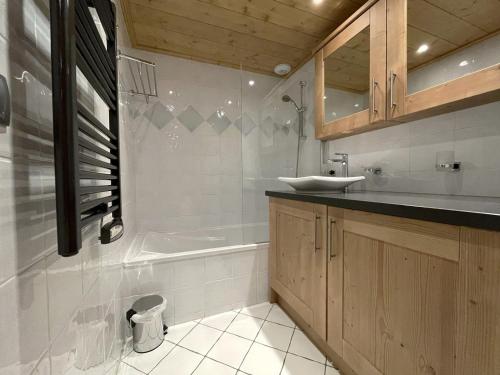 ein Badezimmer mit einem Waschbecken und einer Badewanne in der Unterkunft Appartement Saint-Martin-de-Belleville, 4 pièces, 6 personnes - FR-1-452-133 in Saint-Martin-de-Belleville