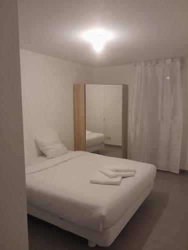 - un lit blanc dans une chambre avec un miroir dans l'établissement MASSALIA FLAT Climatisé, à Marseille