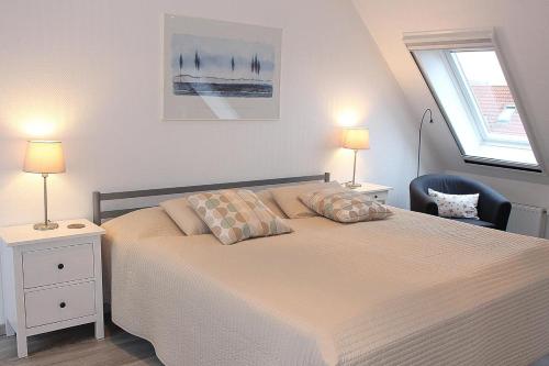 - une chambre avec un lit, deux lampes et une chaise dans l'établissement Apartmentvermittlung Mehr als Meer - Objekt 15, à Niendorf