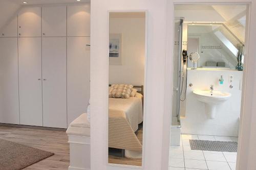 a bathroom with a bed and a sink in a room at Apartmentvermittlung Mehr als Meer - Objekt 15 in Niendorf