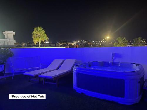 een hot tub en een bank op een balkon 's nachts bij Nissi Avenue Suites in Ayia Napa