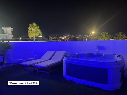 a hot tub and bench on a balcony at night at Nissi Avenue Suites in Ayia Napa