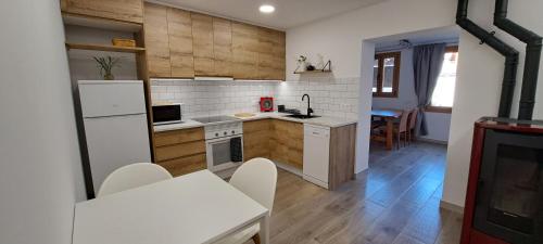 a kitchen with white appliances and a dining room at Cal Bardillo in Bagá