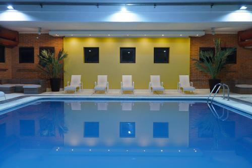 una piscina con sillas y una piscina en Hostal del Sol en San Bernardo
