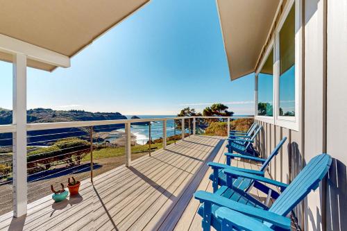 Eine Veranda mit blauen Stühlen und Blick auf das Meer in der Unterkunft Panoramic Ocean View Home in Elk with Beach Access in Elk