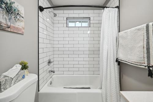 uma casa de banho branca com uma banheira e um chuveiro em Vine Grove Home with Deck, 4 Mi to Saunders Springs! em Radcliff