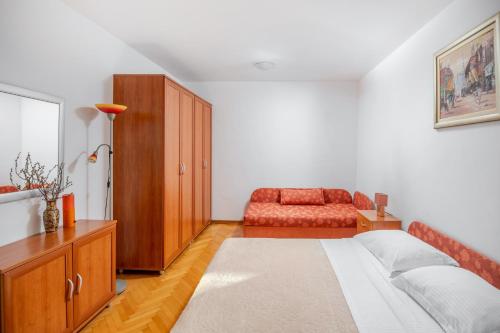 a bedroom with a bed and a red couch at Villa Jana in Marusici 
