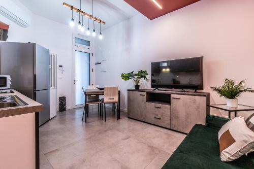 uma cozinha e sala de jantar com uma mesa e uma televisão em Tartini Lofts em Bolonha