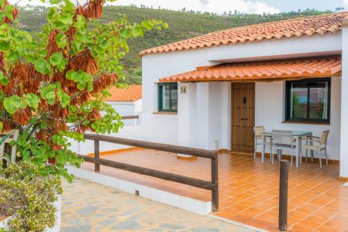 a house with a deck and a table at Complejo Los Veneros in Santa Ana la Real