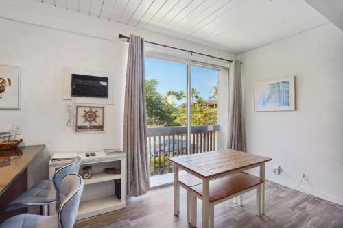 a room with a table and chairs and a window at Less Than 1 Mi to Beach and Town! Airy Kailua-Kona Condo in Kailua-Kona
