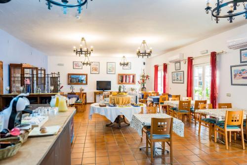 ein Restaurant mit Tischen und Stühlen in einem Zimmer in der Unterkunft Complejo Los Veneros in Santa Ana la Real