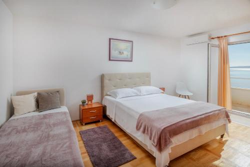 a bedroom with two beds and a window at Villa Jana in Marusici 