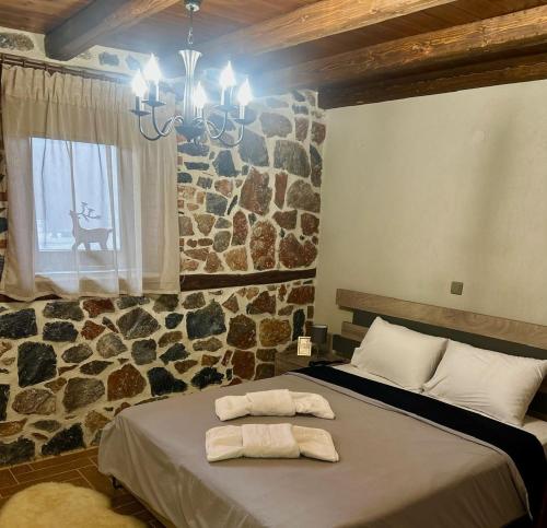 a bedroom with a bed with towels on it at ΑΝΑΛΗΨΗ in Palaios Agios Athanasios