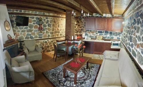 a kitchen with a living room with a couch and a table at ΑΝΑΛΗΨΗ in Palaios Agios Athanasios