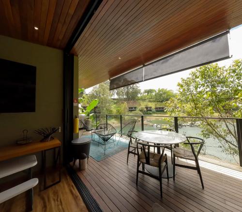 a room with a table and chairs on a deck at Joinn Houtel in Guatapé