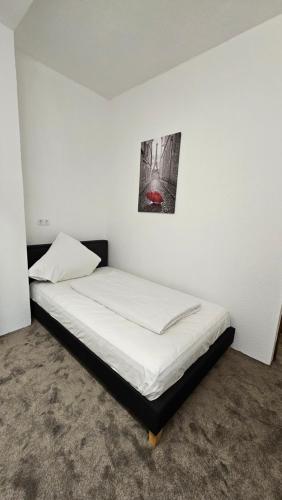 a bed in a room with a picture on the wall at Hotel Kölner Hof in Mülheim an der Ruhr