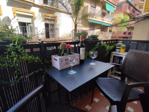 una mesa con dos copas y una botella de vino en Apartamento a metros de la playa, en Fuengirola