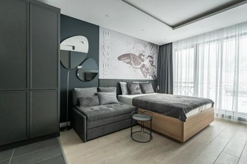 a bedroom with a bed and a couch at Marrilux apartments Residence Hill in Kopaonik