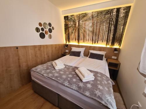 a bedroom with a bed with two towels on it at VilaJahor Natasa A11 in Jahorina
