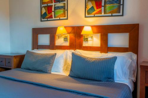 a bedroom with a bed with blue and white pillows at Complejo Los Veneros in Santa Ana la Real