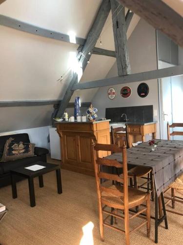 une cuisine avec une table et des chaises dans une pièce dans l'établissement Le Vieux Moulin Chamant Senlis 60300, à Chamant