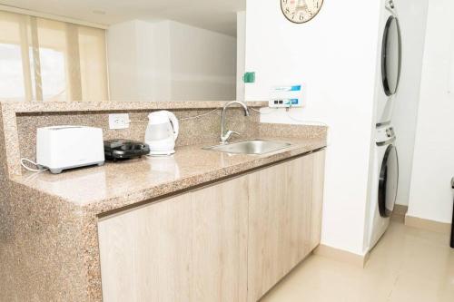 a kitchen counter with a sink and a refrigerator at Ocean-Confort in Cartagena de Indias