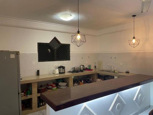 a kitchen with a counter top and two pendant lights at Wonder Homestay in Negombo