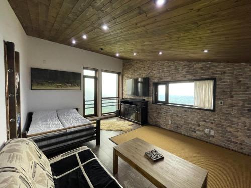 a living room with a bed and a brick wall at ESCAPE in Petroşani