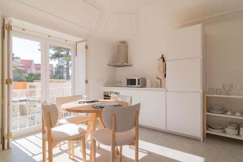 a kitchen and dining room with a table and chairs at Chalet Maria da Assunção in Estoril