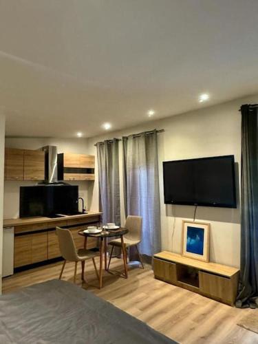 - une chambre avec un lit, une table et une télévision dans l'établissement Chalet cosy et coconing, à Meyzieu