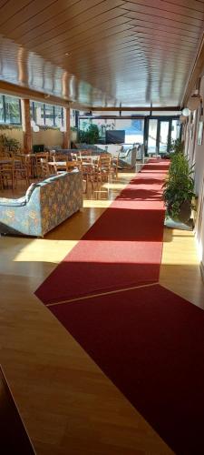 - un long tapis rouge dans une chambre dotée de tables et de chaises dans l'établissement Casa Lares, à Falcade
