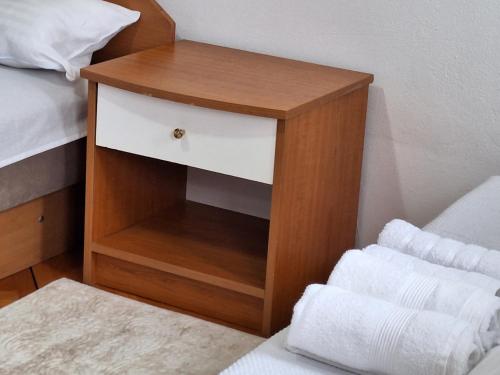 a small wooden night stand next to a bed at RIVIJERA GREEN in Belgrade