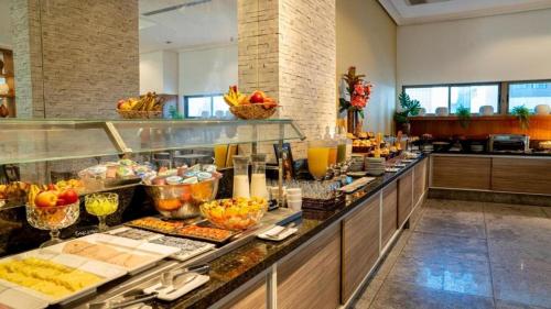 una línea de buffet con mucha comida en exhibición en Betel Beach Flat Boa Viagem, en Recife