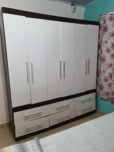 a bedroom with white cabinets and a bed at Casa Vermelha Dois in Antonina