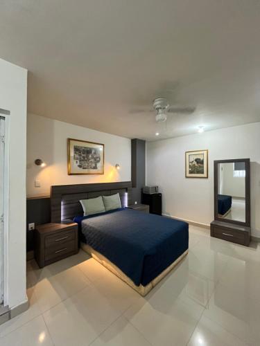 sypialnia z niebieskim łóżkiem i lustrem w obiekcie BED BED HOTEL CORREGIDORA w mieście Torreón