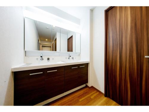 a bathroom with a sink and a large mirror at VILLA KOSHIDO ODORI - Vacation STAY 04756v in Sapporo