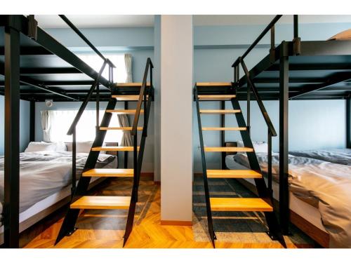 a room with two bunk beds and a staircase at VILLA KOSHIDO ODORI - Vacation STAY 04760v in Sapporo
