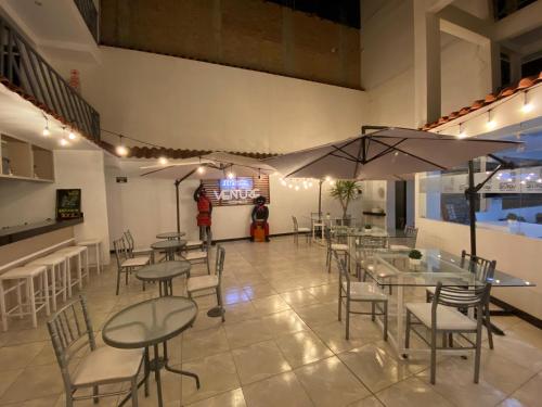 a restaurant with tables and chairs and a person in the background at Hotel Venture in Chincha Alta