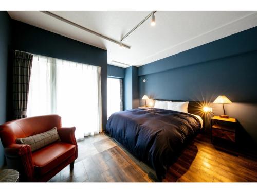 a bedroom with a bed and a chair and a window at VILLA KOSHIDO ODORI - Vacation STAY 04750v in Sapporo